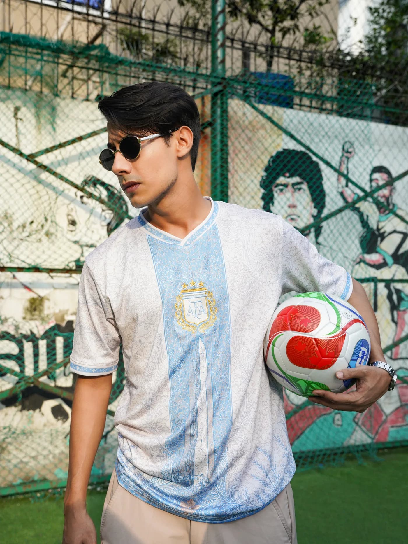Model in the Albiceleste jersey with a ball under his arm, mural behind
